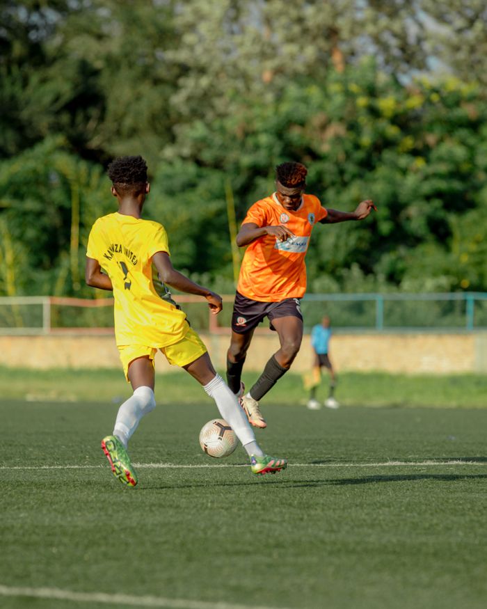 Dynamic image of two soccer players in action during a match on an outdoor field.