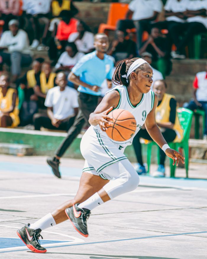 Dynamic shot of a female basketball player dribbling on an outdoor court.